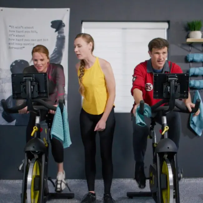 two men on exercise bikes under the care of a fitness trainer at Uplift Recovery Center