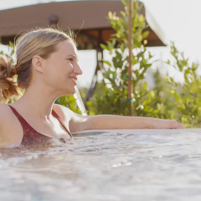 A woman relaxing in the hot tub at Uplift Recovery Center