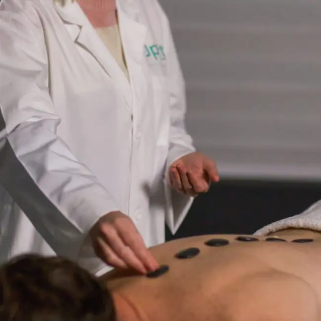 A acupuncture and message therapist tending to a patient at Uplift Recovery Center