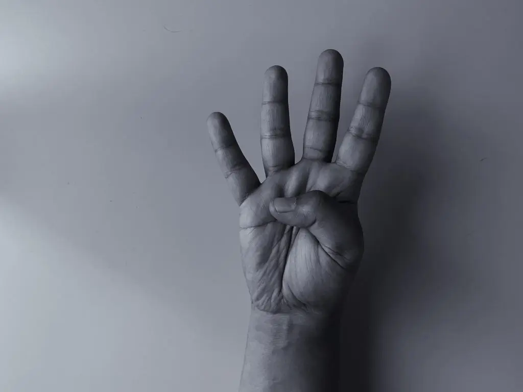 Hand holding up four fingers, representing the cycle of addiction