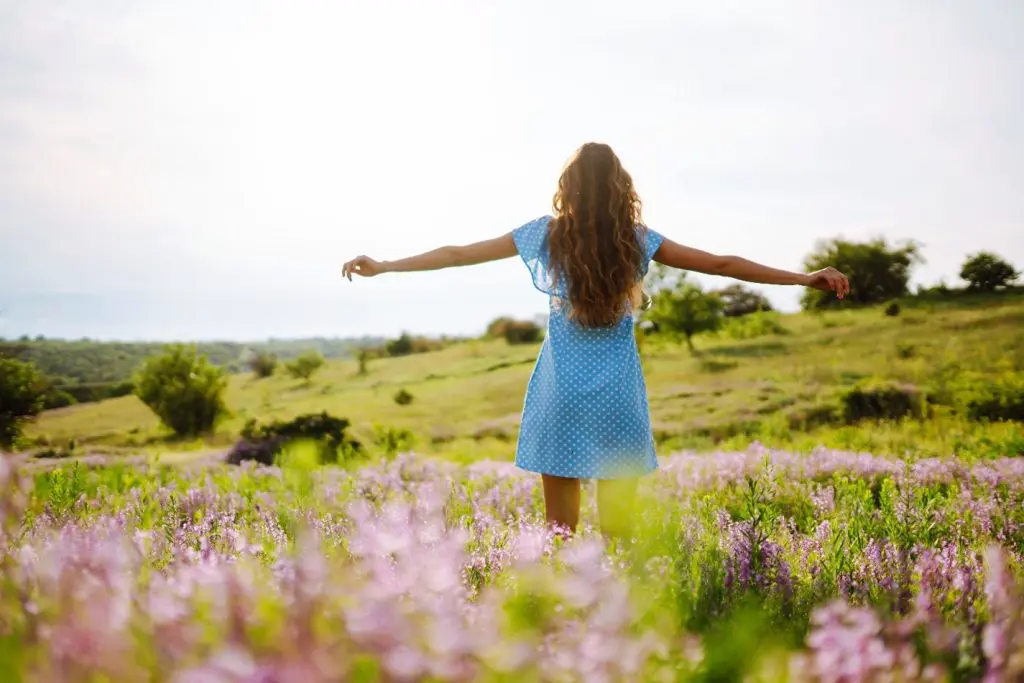 a woman playing in a field, enjoying the benefits of residential treatment
