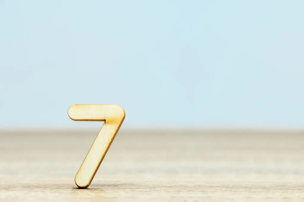 a wooden number "7" on top of a table, highlighting the 7 common symptoms of alcohol withdrawal