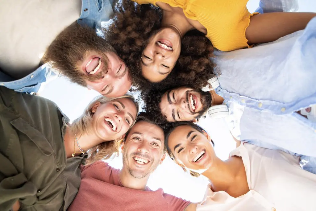 a group of friends in a circle taking a selfie, highlighting the importance of how to find sober friends while in recovery