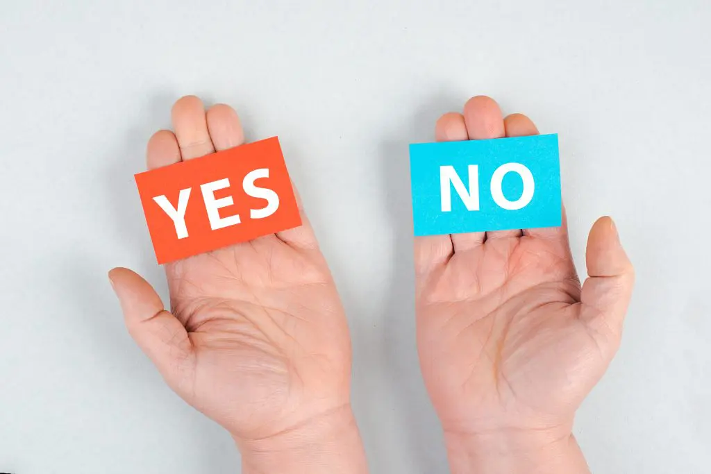 open palms holding "yes" and "no" on sticky notes, begging the question "can you drink rubbing alcohol"?