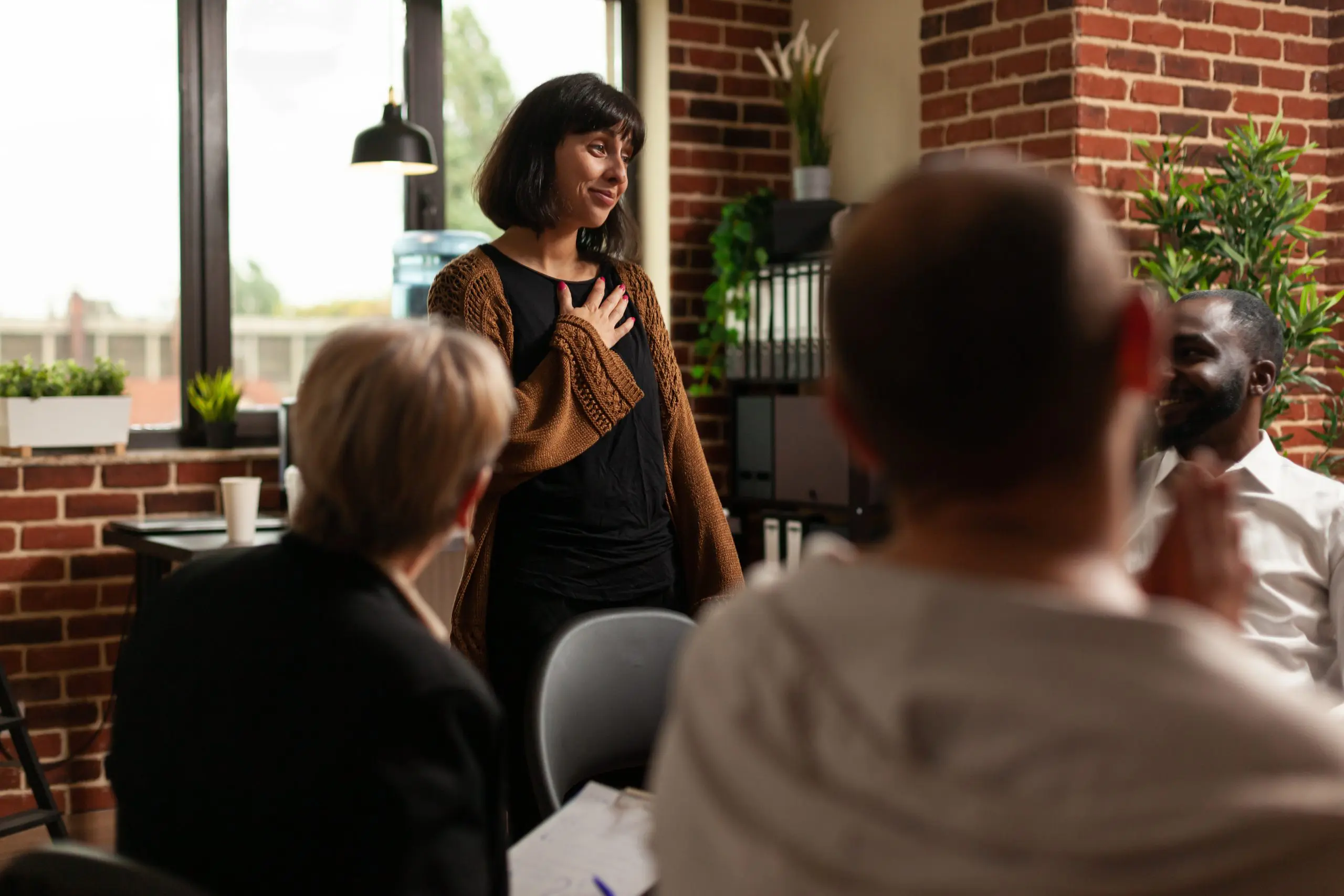a woman receiving an applause during her aa meeting as a sign to celebrate National Sober Day