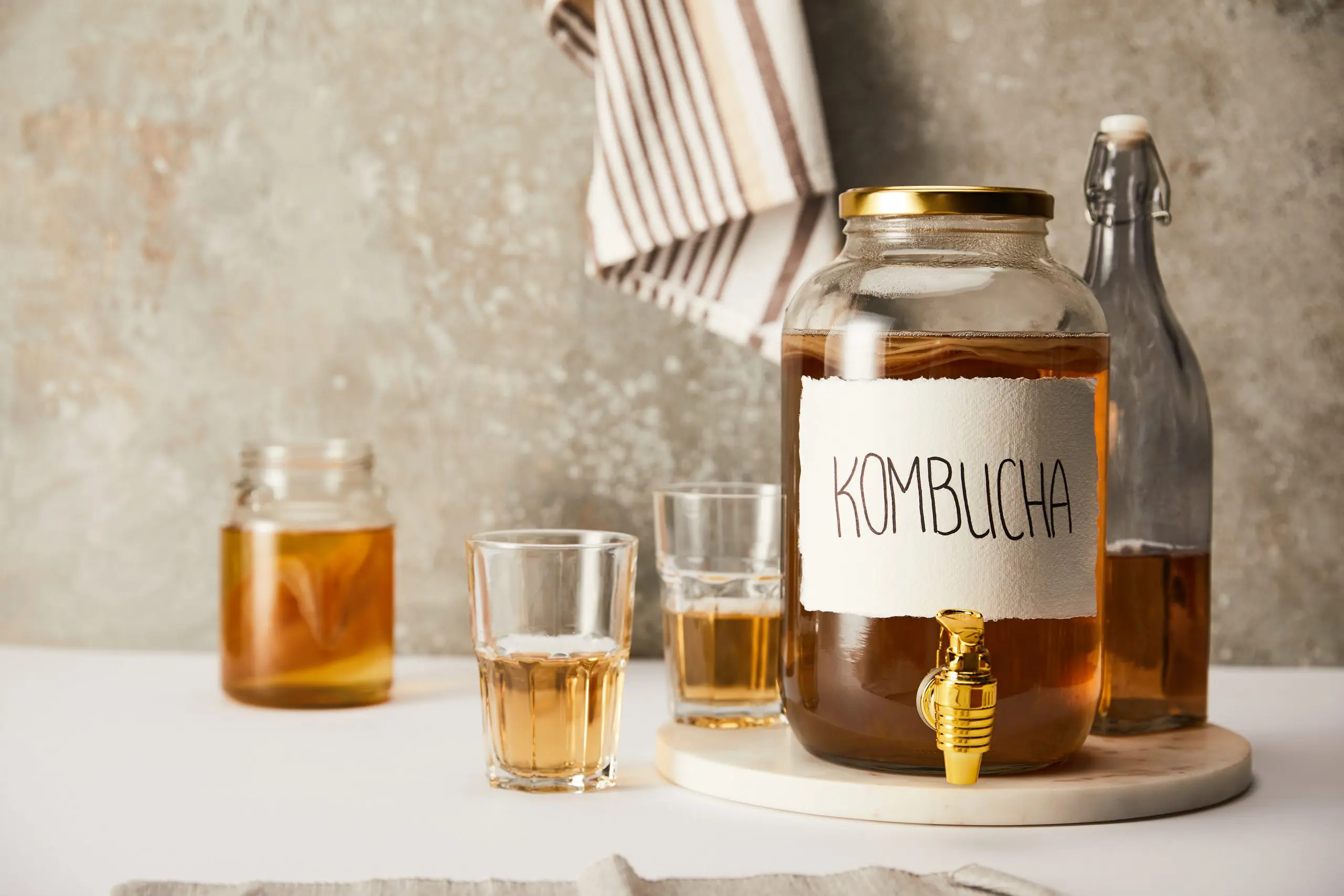 a jar of Kombucha with accompanying glasses to show alcohol free drinks during Sober October