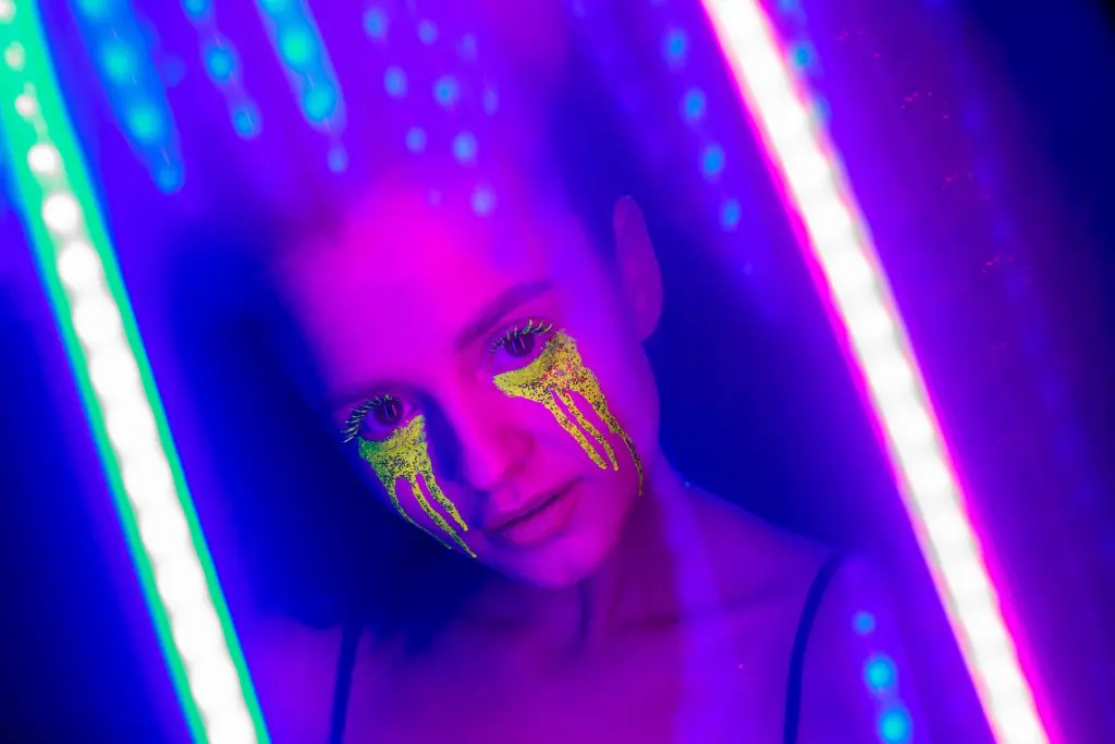a girl with stylized makeup under neon lights to represent an acid panic attack