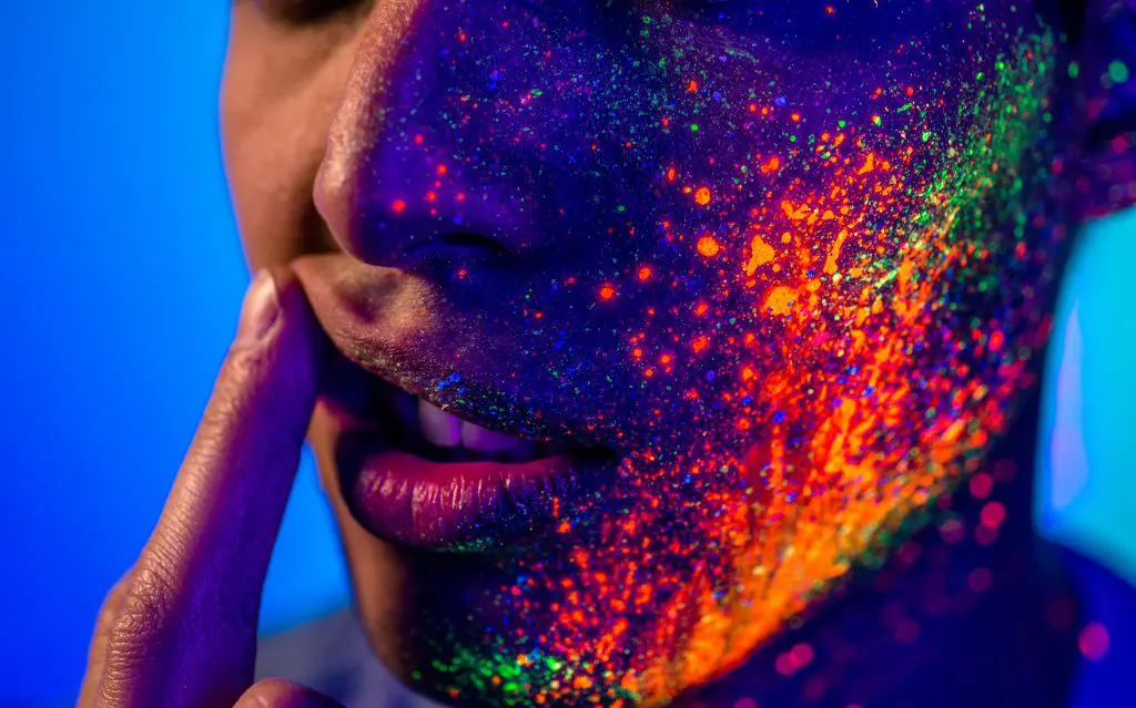 a woman's face covered with paint implying the withdrawal symptoms of acid