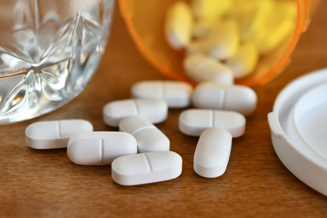 pills falling out of a prescription bottle highlighting opioid addiction