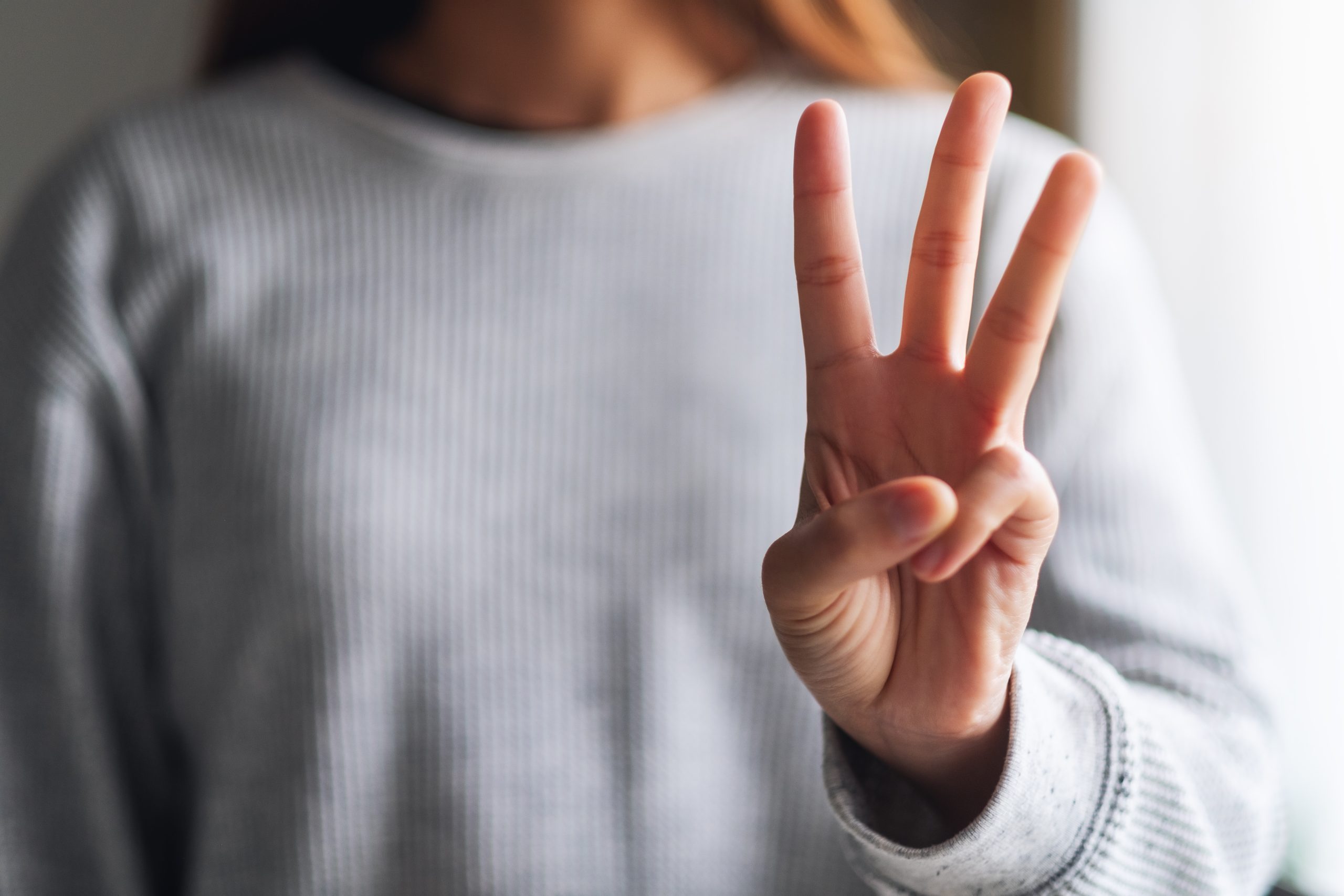 a woman holding up 3 fingers to show 3 examples of active and passive recovery techniques