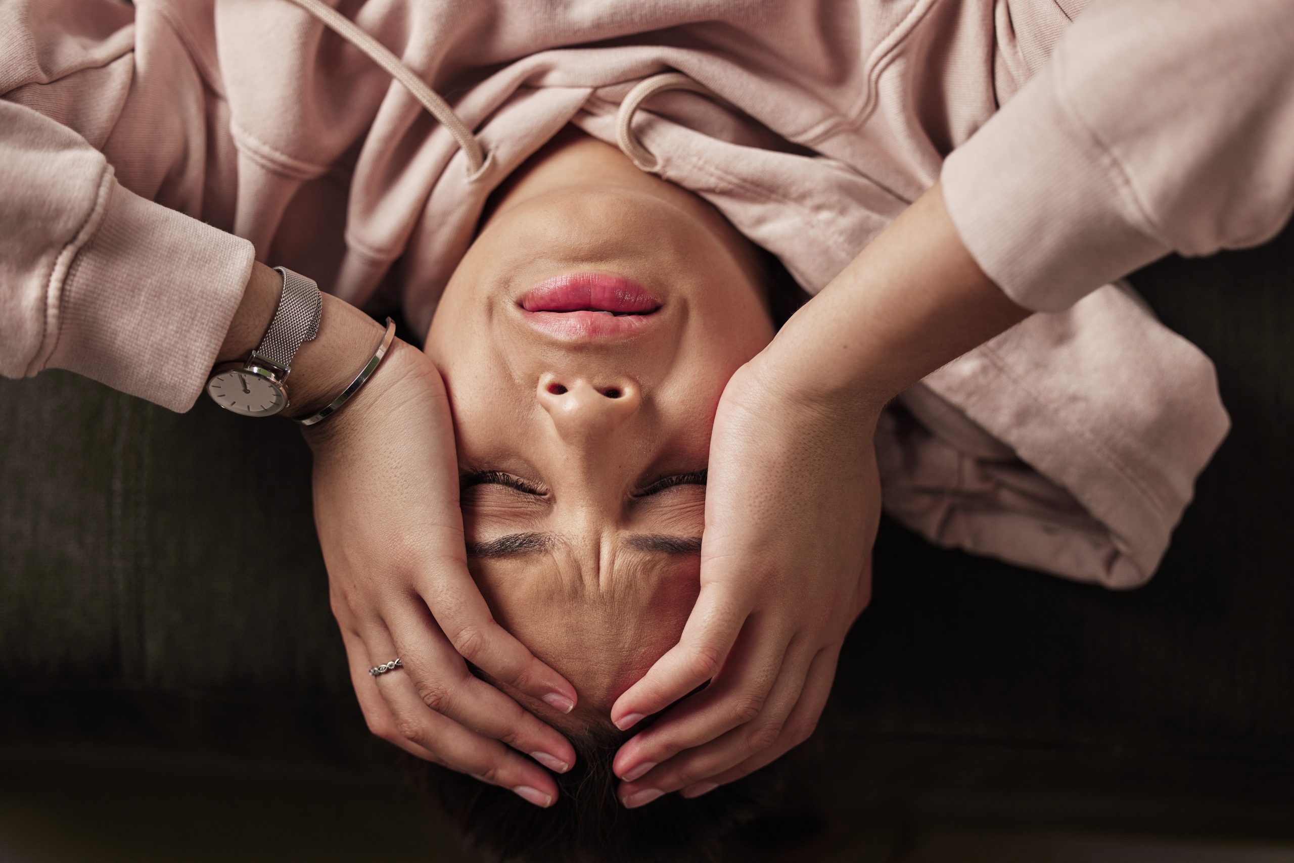 a woman lying down with her hands on her head, suffering from post acute withdrawal syndrome