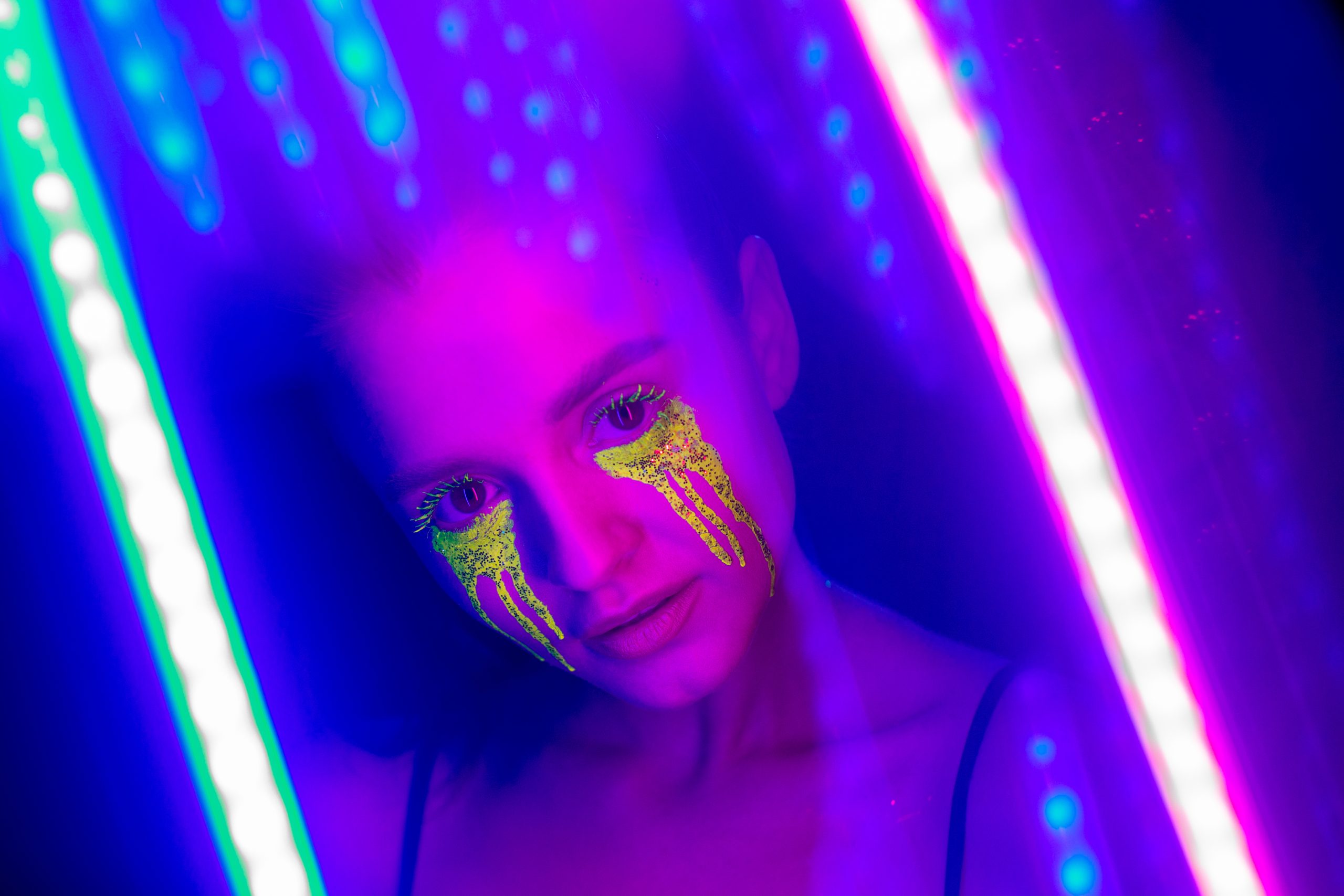 a girl with stylized makeup under neon lights to represent an acid panic attack