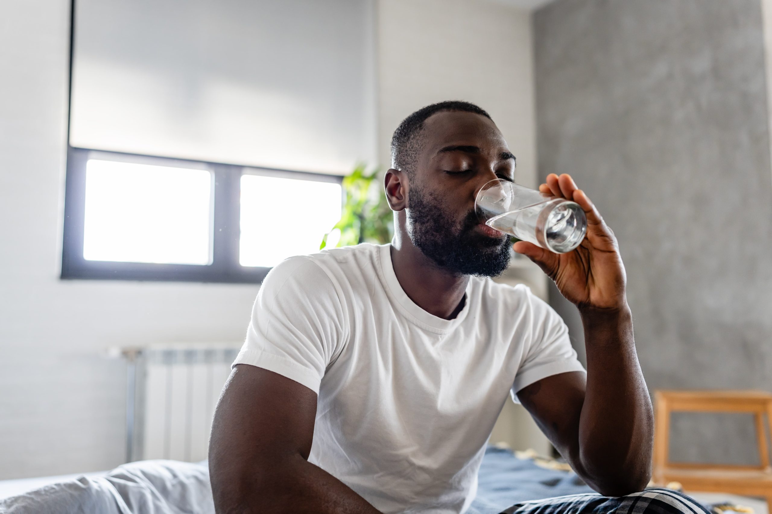 Person staying hydrated in the first 30 days of sobriety with a morning glass of water